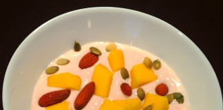 Yoghurt med proteinpulver, græskarkerner, sprøde mandler og sød mango